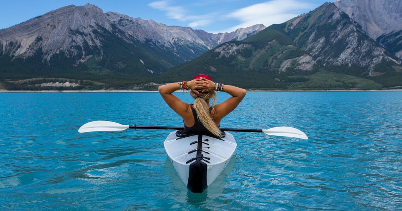 Donna su una canoa in mezzo a un lago