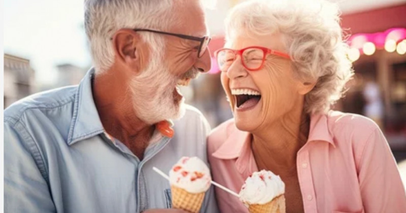 Due anziani ridono mentre mangiano un gelato